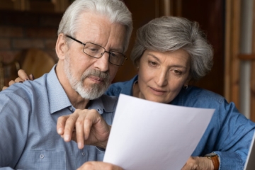 Ältere Immobilieneigentümer informieren sich über das Thema Eigentümergrundschuld